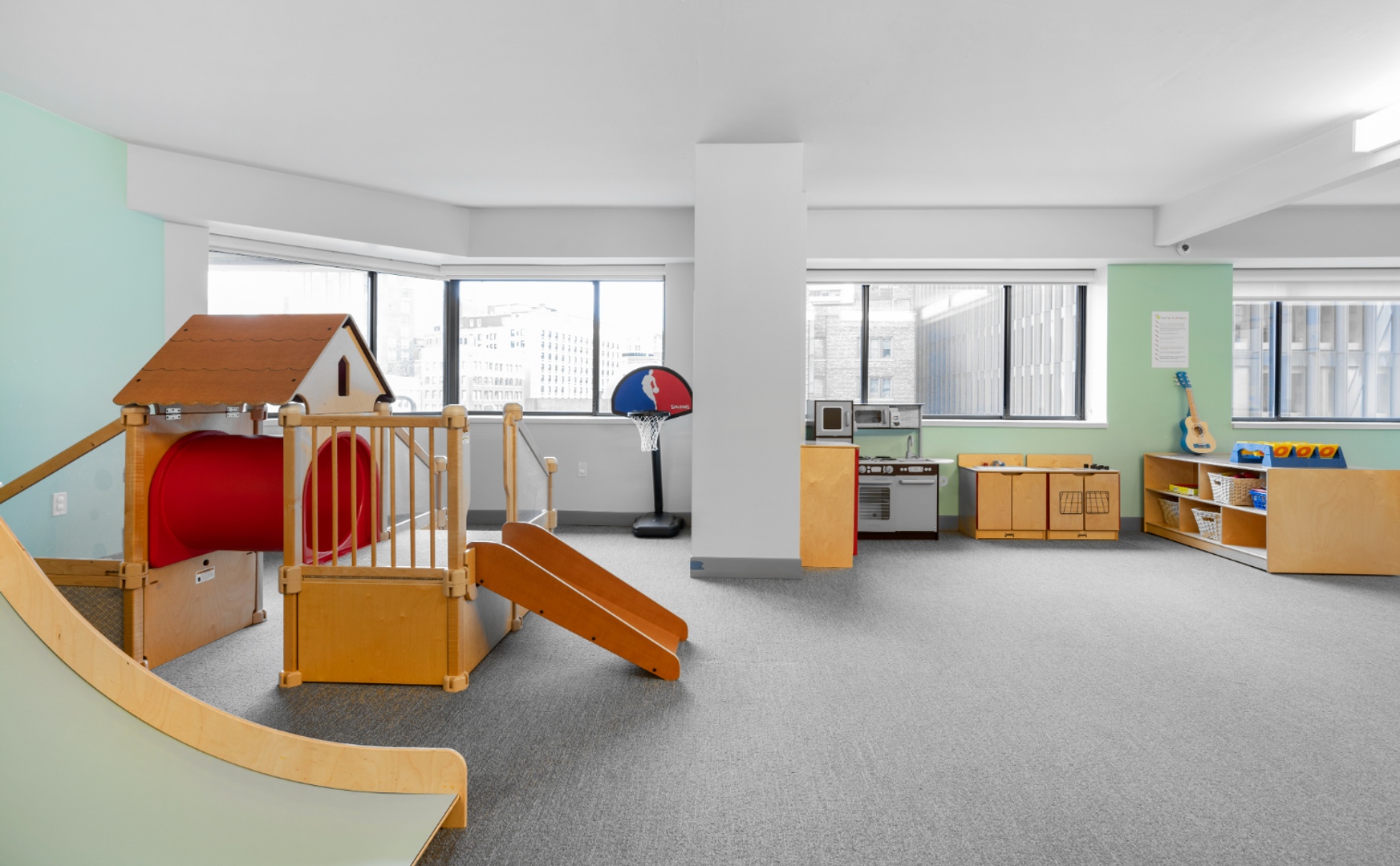 Playroom with playhouse and toy kitchen.