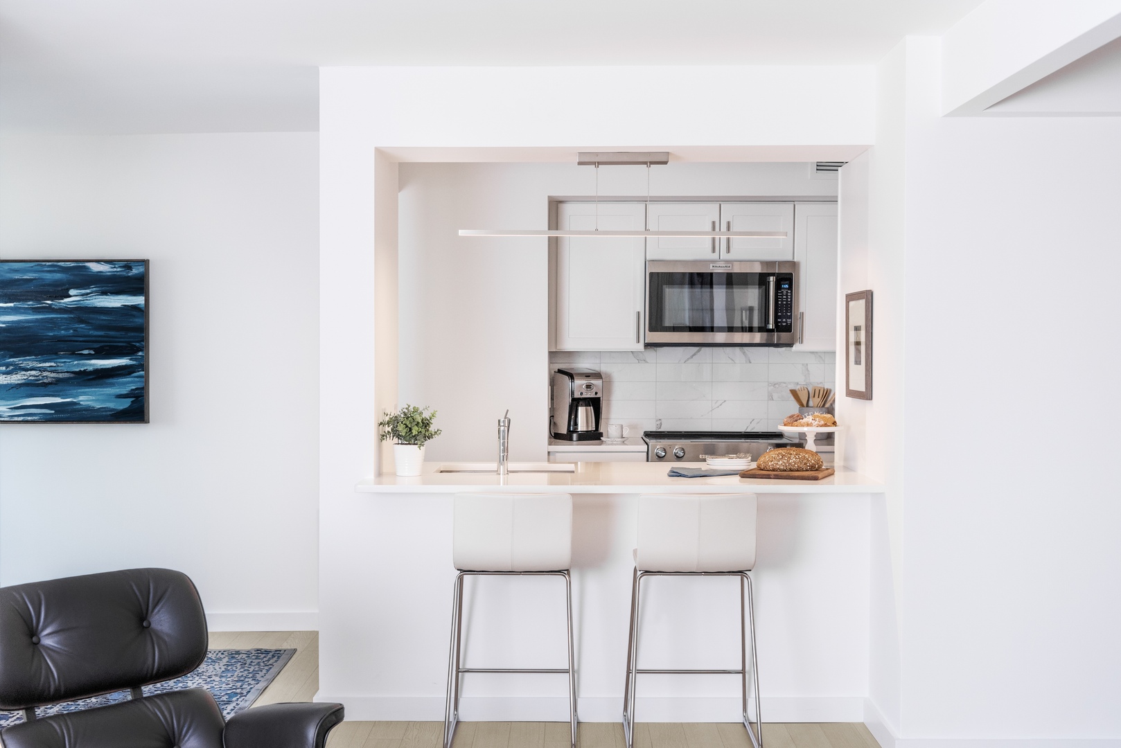 Kitchen counter with barstools and windows.